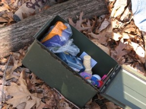 A typical "large" geocache stashed with trinkets, trackables and a log book. 